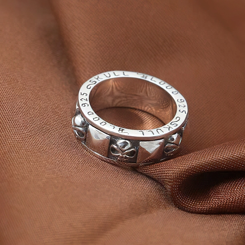 Engraved skull blood text sterling silver spinner ring vintage texture brown background