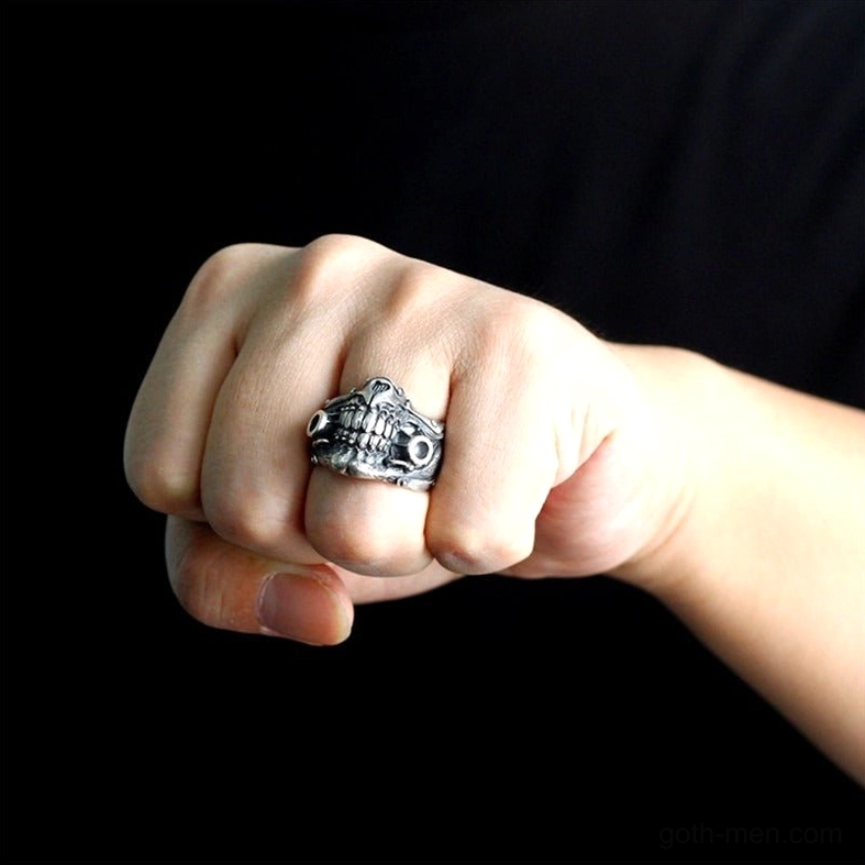 Man's fist wearing gothic skull ring on index finger - styled for alternative rock and punk aesthetic