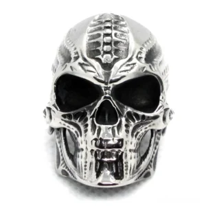 Front view of engraved skull ring displaying detailed biomechanical carvings and gothic design elements in silver metal
