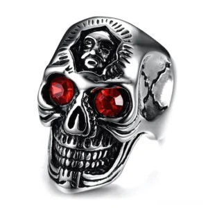 Gothic skull ring with red crystal eyes and intricate skeletal engraving, front view showcasing memento mori design