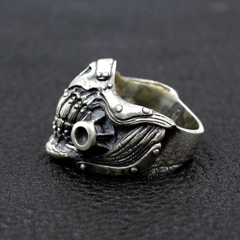Right oblique side view of punk skull mask ring with single hollow port detail on black leather background