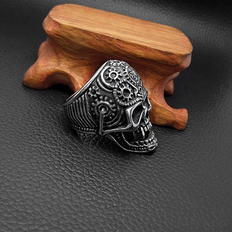 Stainless steel gothic skull ring side profile showing sharp fangs and engraved mechanical gear patterns
