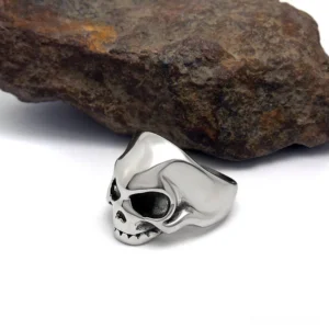 Punk rock skull ring side profile, stainless steel skeleton band with detailed facial features, gothic alternative jewelry side angle