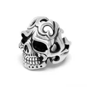 Gothic hollow skull stainless steel ring with tribal carved patterns, front flat view on white background showing vintage silver finish