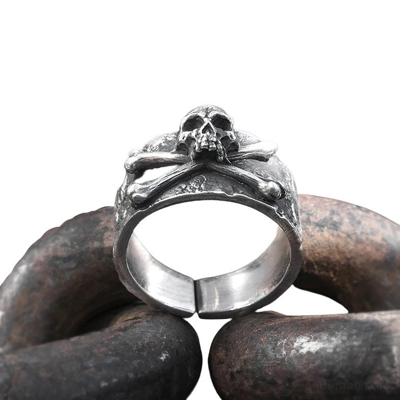 Vintage sterling silver skull crossbones ring displayed on aged metal chain showing oxidized patina