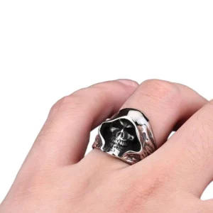 Hooded skull punk ring worn on male hand close-up showing fit and antique silver finish with hollowed skull design