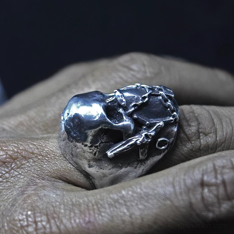 Gothic skull ring worn on human finger, top-down view showcasing polished silver chain mask and lock ornament
