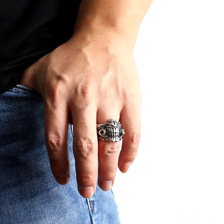Man wearing gothic skull mask ring on middle finger - styled with denim and black top for alternative fashion look