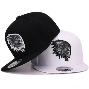 Gothic skull embroidered snapback cap in black and white colorways, flat brim design from side angle