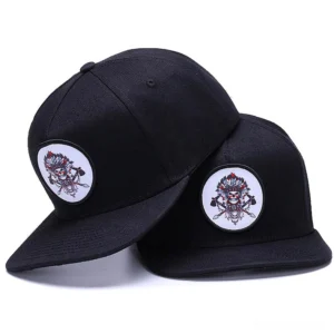 Black and white skull embroidered gothic snapback caps displayed side by side on white background, showing three-quarter view with adjustable back straps