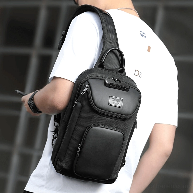 Male model wearing black sling crossbody bag on right shoulder rear side view urban outdoor setting