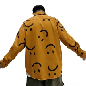 Back view of men's gothic smiley print shirt in burnt orange, full coverage smiley graffiti design, model wearing oversized fit