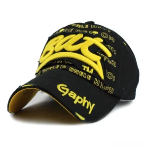 Black gothic snapback cap with bold yellow 3D BUT embroidery and frayed brim detail