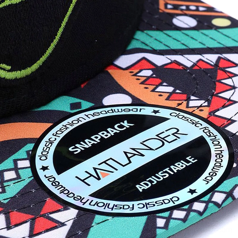 Top-down close-up of black snapback cap showing geometric printed brim pattern and adjustable plastic snapback closure