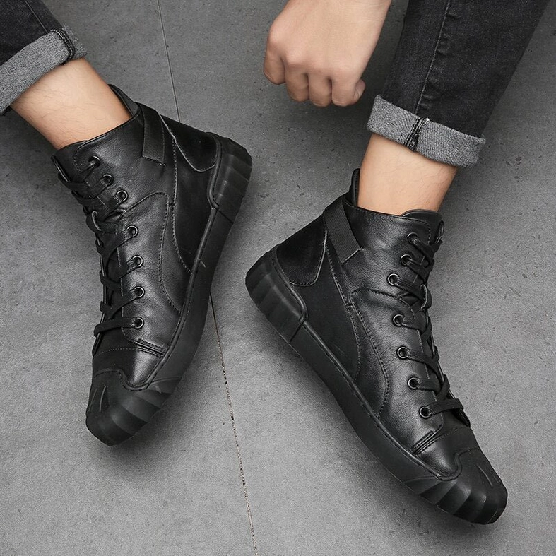 Male model wearing black leather high-top gothic sneakers side profile showing lace-up design and clean construction