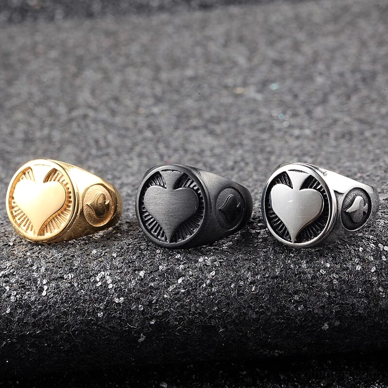 Three gothic spade stainless steel rings - black, gold, and silver variants on dark fabric