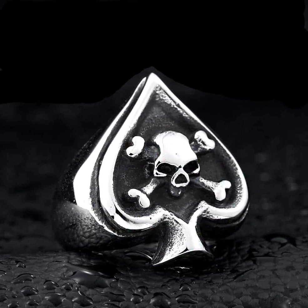 Silver stainless steel gothic spade skull ring with water droplets on dark textured backdrop showing biker aesthetic
