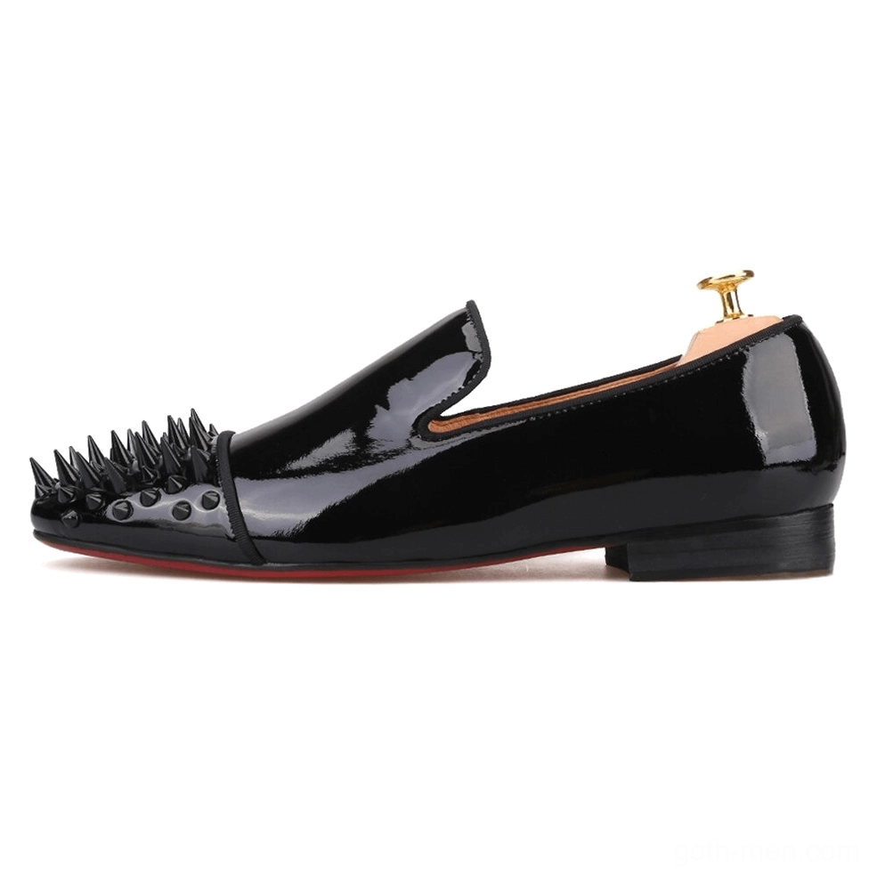 Single black patent leather gothic loafer in full side profile, featuring gold shoe tree support and red rubber outsole
