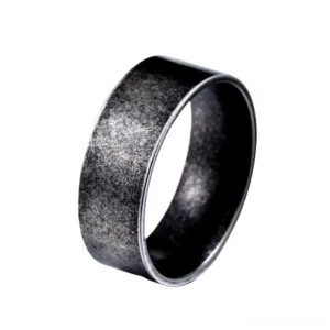 Minimalist gothic stainless steel band ring with matte black finish, three-quarter side view on white background, showing smooth polished surface and vintage metal aesthetic