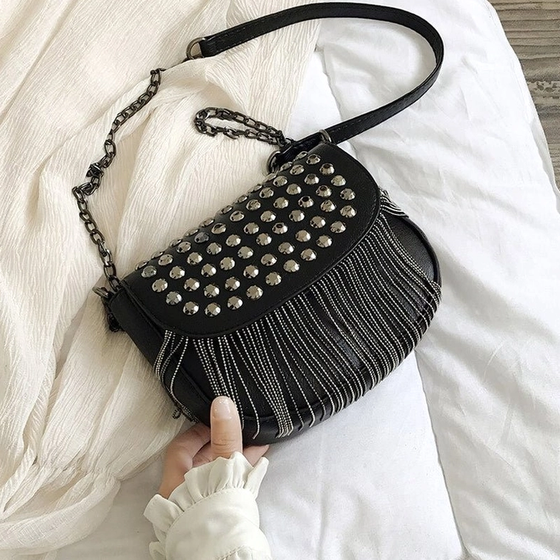 Black gothic studded shoulder bag flat lay side view highlighting soft leather texture and tassel accents