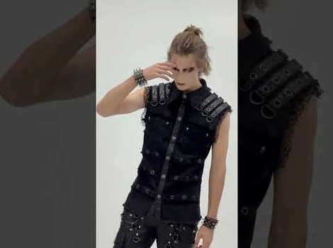 Gothic black leather vest with studded straps and rivet fasteners, paired with partial view of black cargo pants, showcasing lace and metal hardware accents