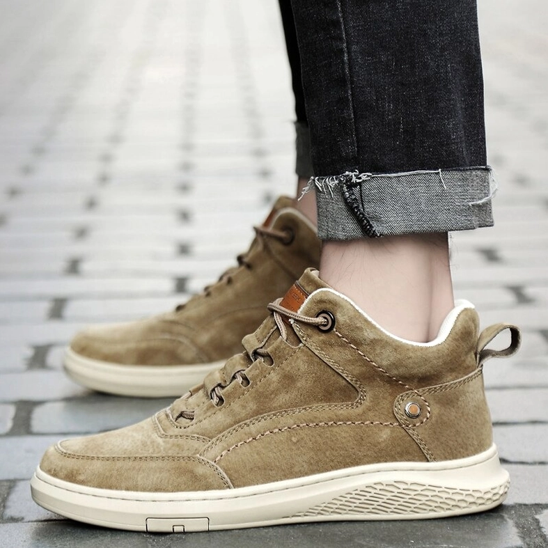 Frontal perspective of beige suede gothic ankle boots emphasizing lace-up system and proportions