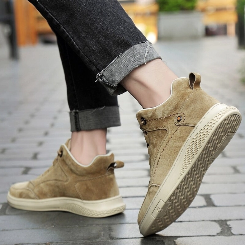 Full-body product shot of beige suede gothic ankle boots from front angle on neutral background