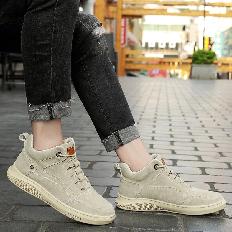 Three-quarter view of brown suede gothic ankle boots on white studio background