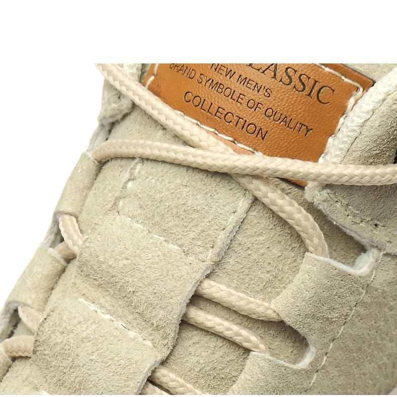 Close-up detail of suede gothic ankle boot collar, branded leather tag, and flat cotton laces