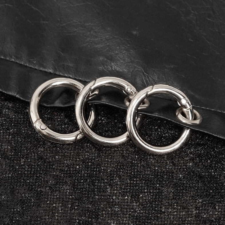 Metal O-ring decoration detail on gothic sweatshirt with leather trim and textured base fabric