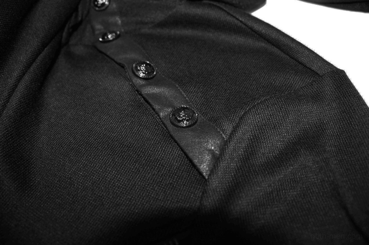 Close-up detail of black gothic sweatshirt shoulder metal buttons and leather strip accent on knit fabric