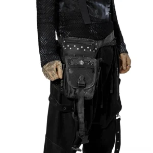 Gothic tactical waist bag with spike rivets and skull emblem worn by tattooed male model, front view studio photography