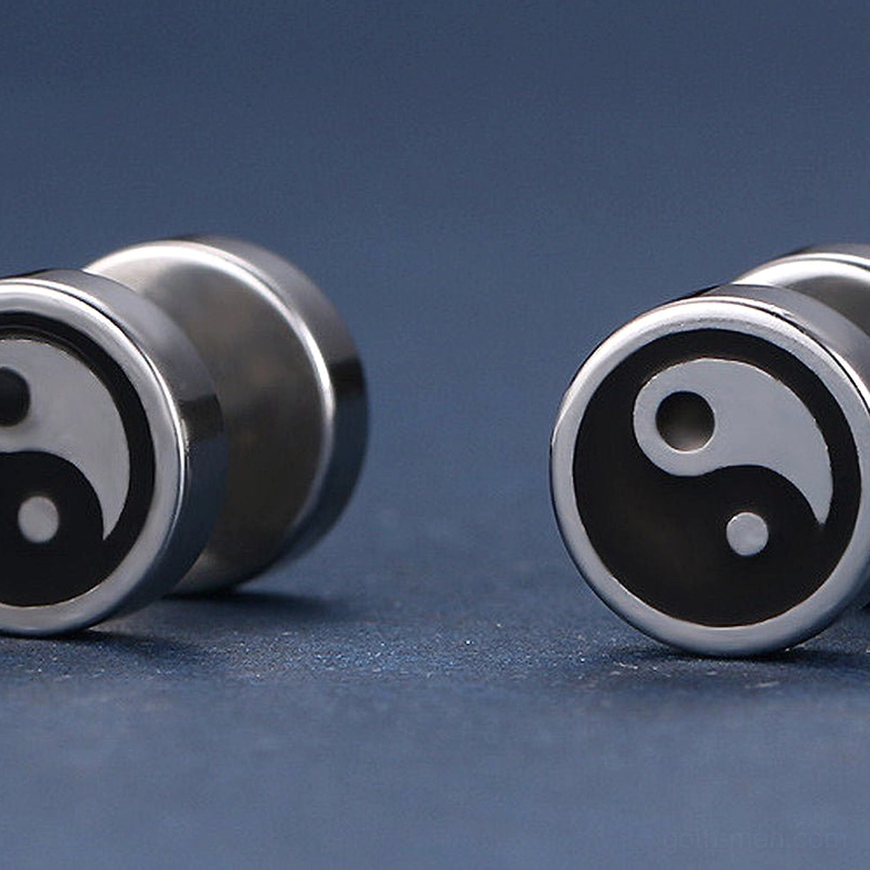 Pair of Tai Chi stud earrings on dark blue background, showing both earrings with polished stainless steel yin yang pattern