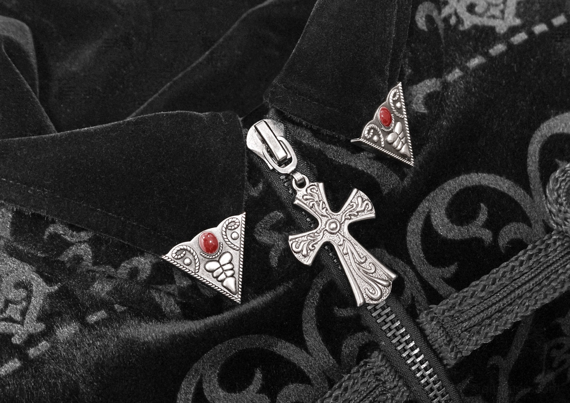 Close-up detail of gothic tailcoat collar and cross-shaped metal zipper pull with red gemstone accents