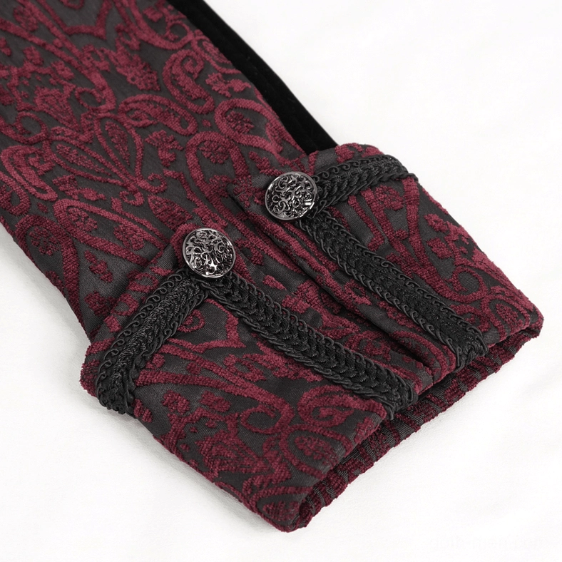 Close-up detail of gothic tailcoat cuff showing embossed damask jacquard fabric, braided black trim, and engraved metal button hardware