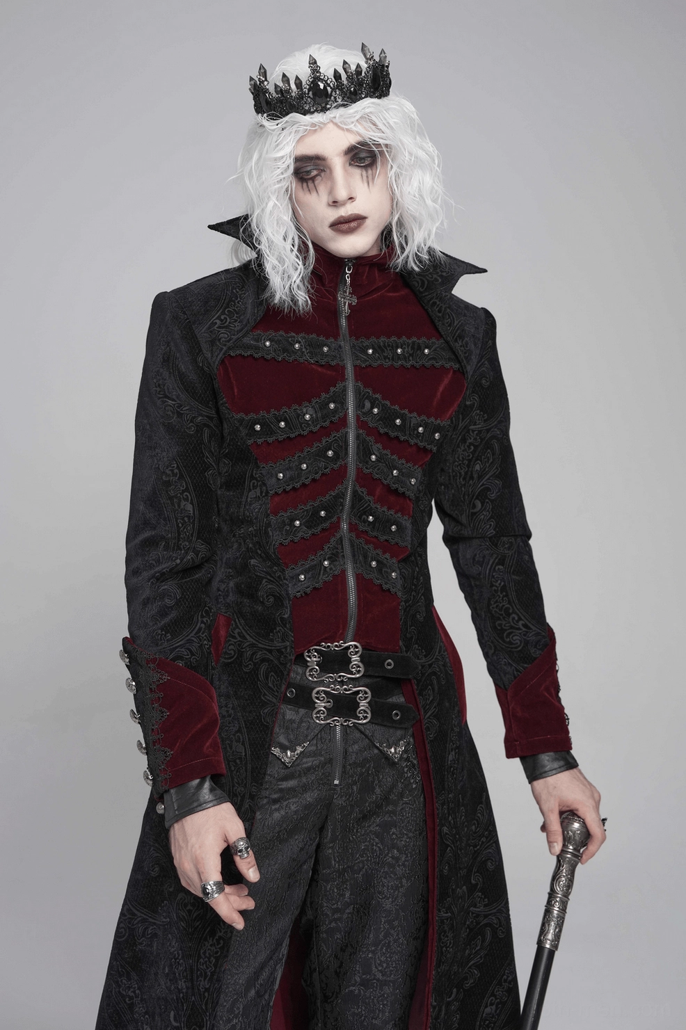 Male model wearing black Victorian gothic tailcoat with wine red velvet trim in dramatic studio setting, showcasing the tailcoat's theatrical presence