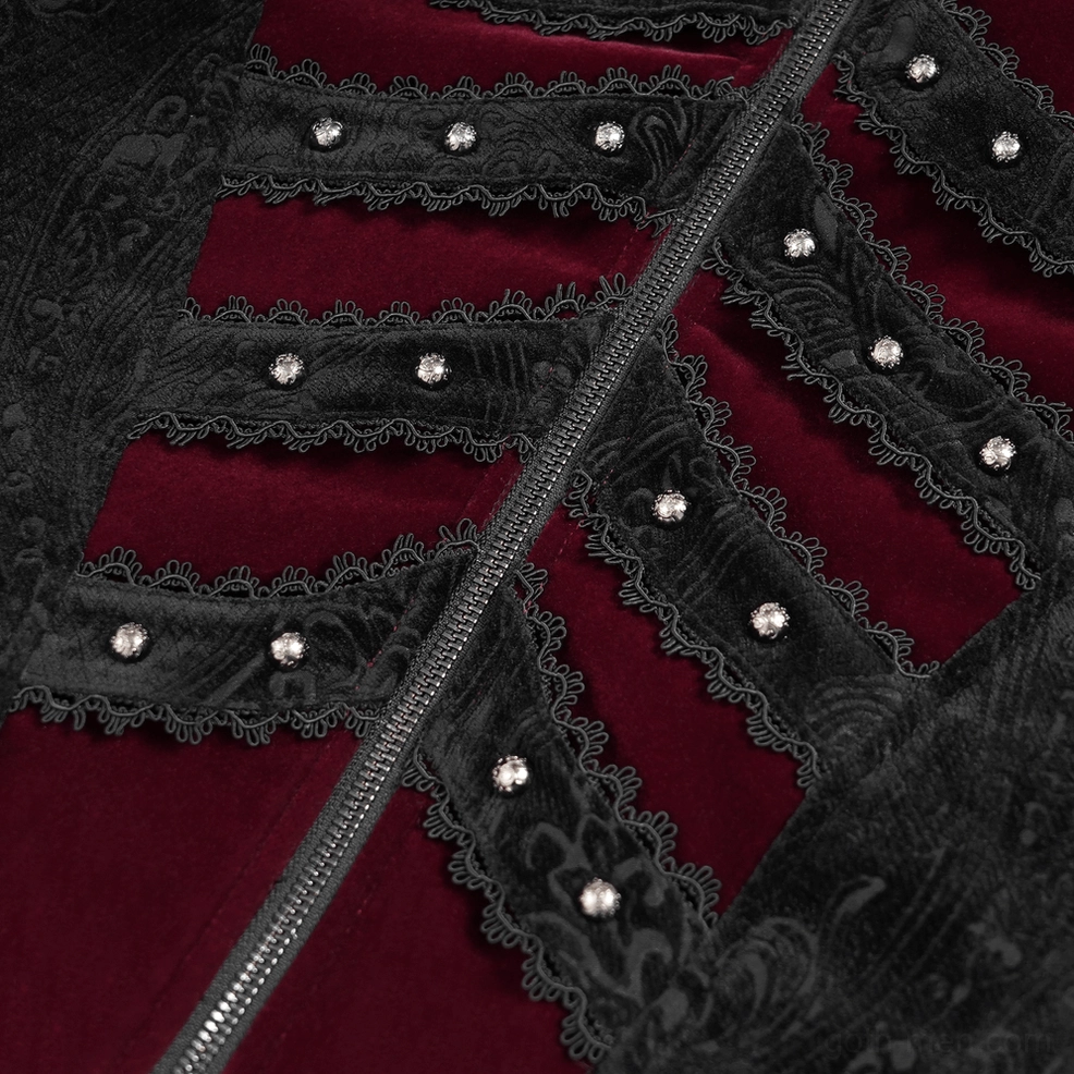 Close-up detail of gothic tailcoat front panel showing studded skeleton lace trim, metal zipper fastening, and rich wine red velvet base layer