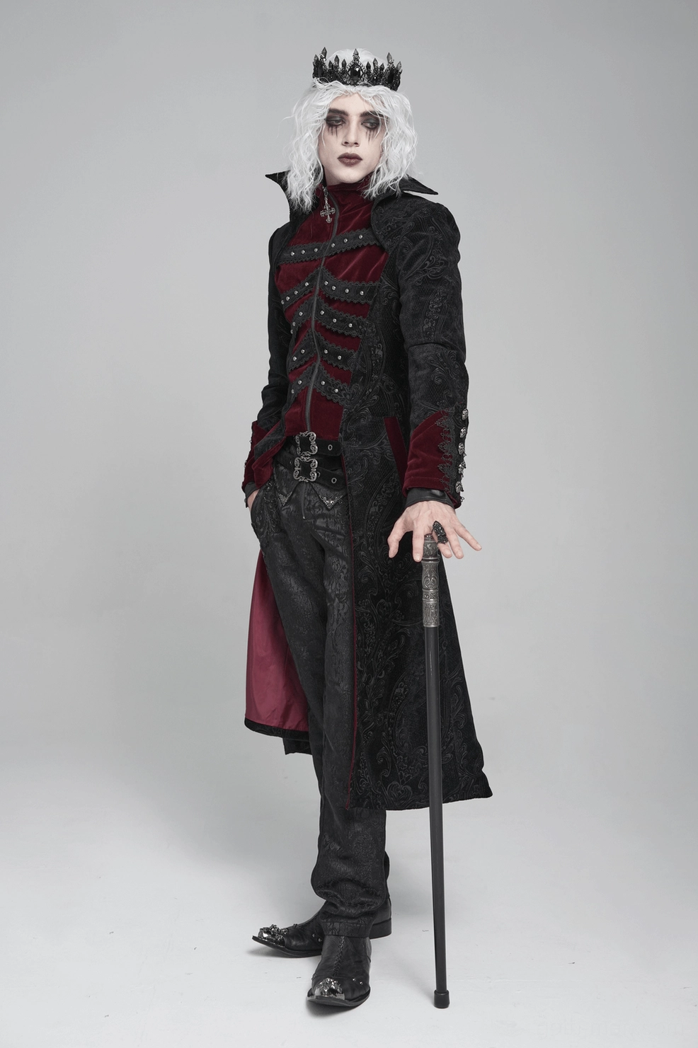 Studio display of black gothic Victorian tailcoat with wine red velvet trim, embossed brocade, and decorative braiding in pure white background