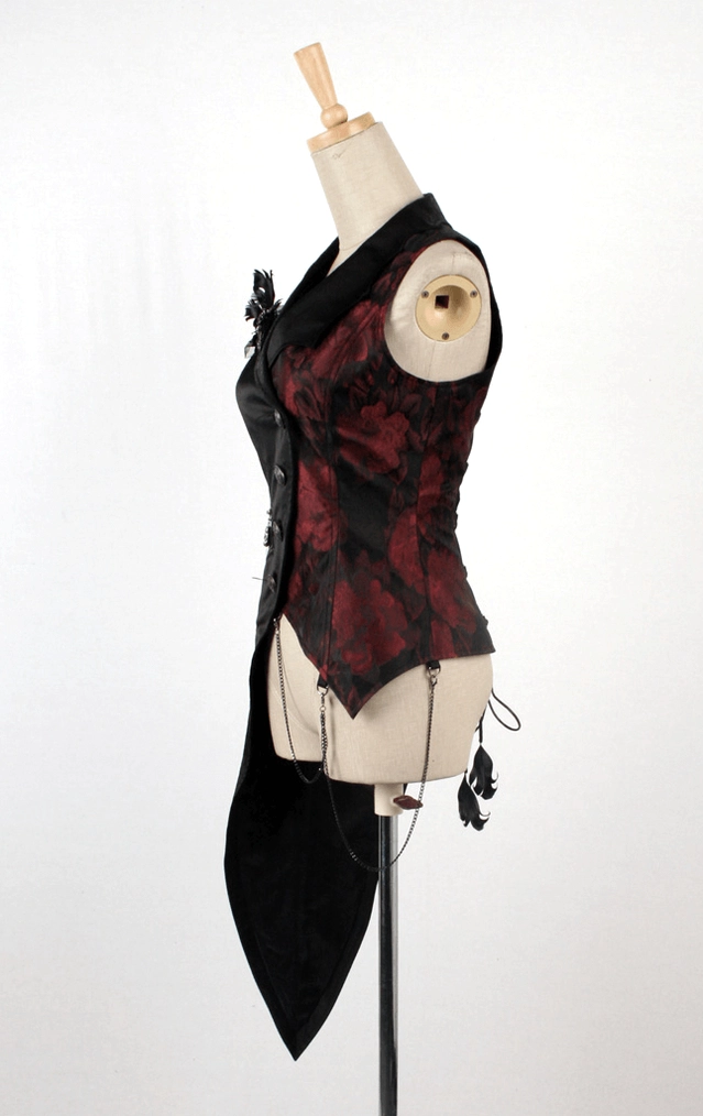 Left side front view of black gothic tailcoat vest showing red floral brocade panel, decorative metal brooch, and hanging chain charms