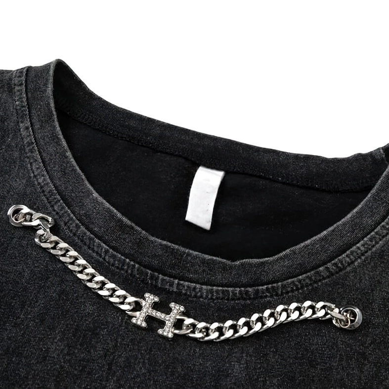Close-up detail of silver curb chain with rhinestone H charm on gothic tank top neckline