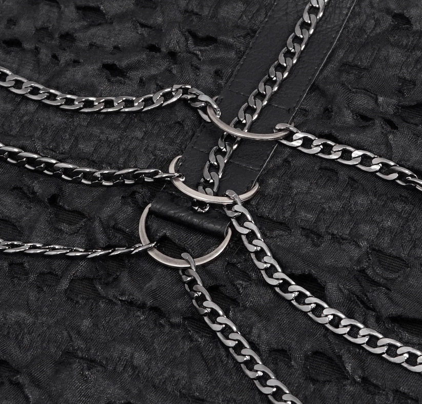 Extreme close-up of metal O-rings and curb chain hardware on black gothic tank top