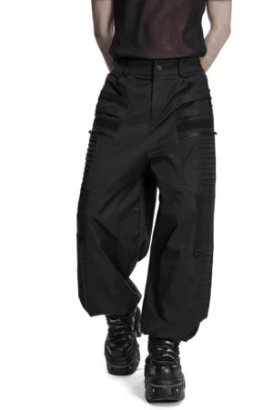 Black gothic techwear wide leg pants with 3D pressed strips, front three-quarter view on male model showing zipper pockets and ribbed leg details