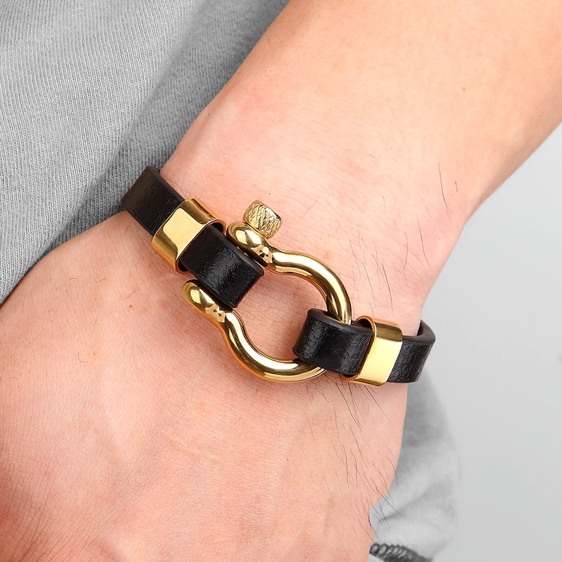 Man wearing gold and black gothic toggle leather bracelet on wrist - casual everyday alternative style