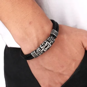 Men's black leather totem bracelet worn on wrist in casual daily setting, close-up side view showing magnetic clasp and carved totem detail