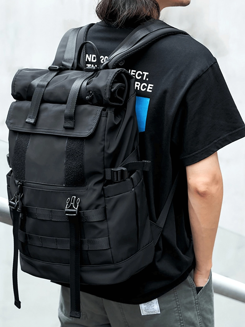 Man wearing daily roll-top travel backpack side back view outdoor street scene casual urban styling