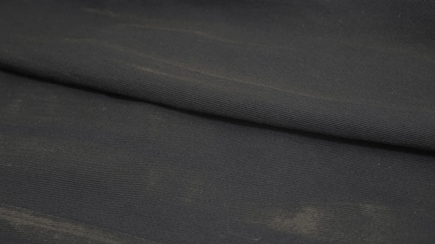 Fabric texture close-up of gothic trench coat showing washed black canvas and distressed matte finish