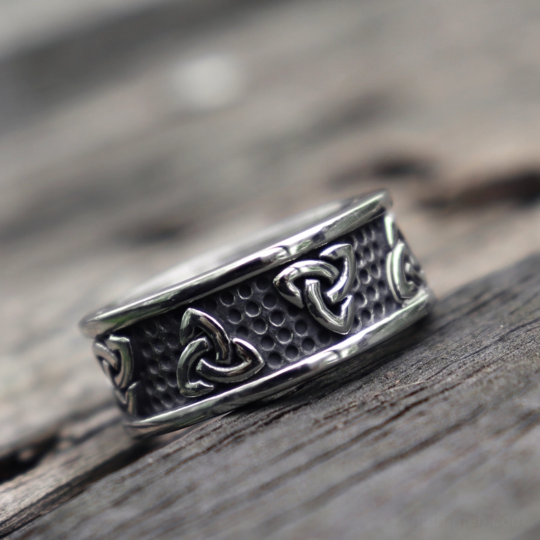 Celtic triquetra stainless steel ring low side perspective on wooden table surface