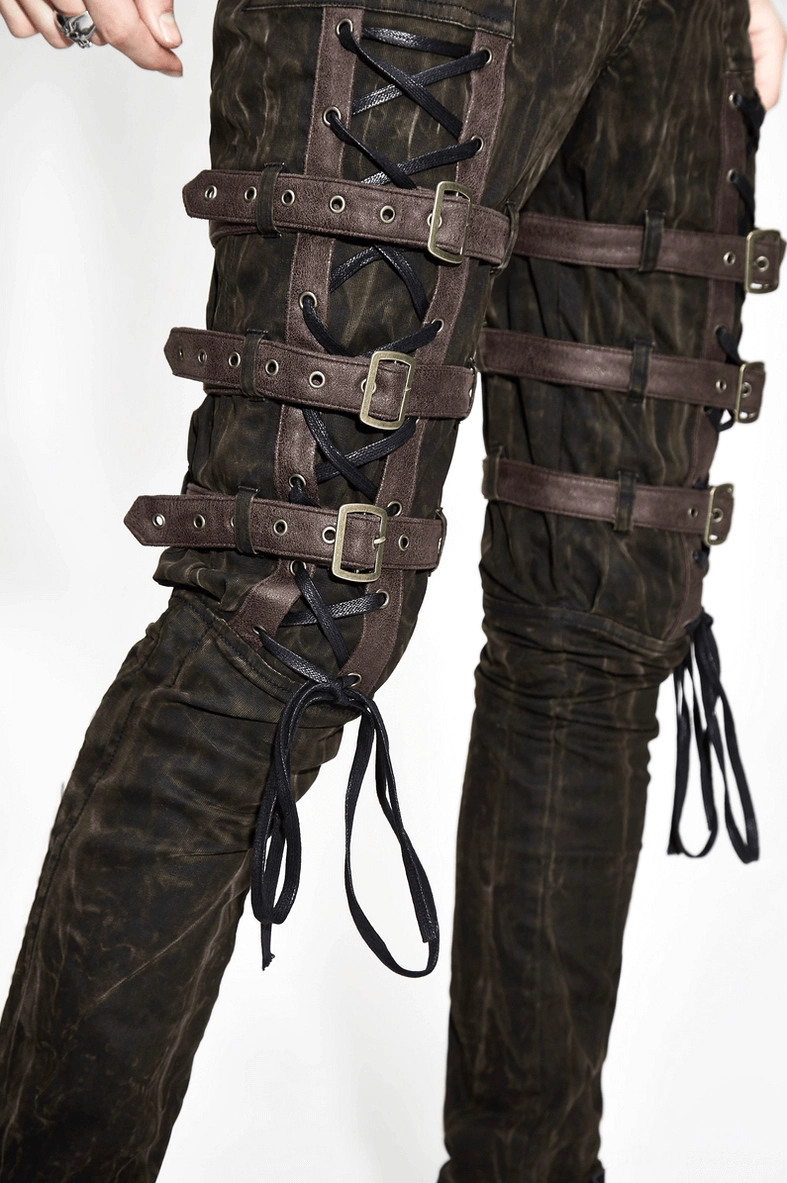 Gothic slim-fit trousers leg detail showing multiple metal buckles and crisscross lace tie hardware on tapered leg
