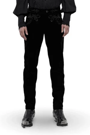 Front full-body view of black velvet gothic slim trousers with baroque scroll embroidery on pockets, styled with ruffled gothic shirt