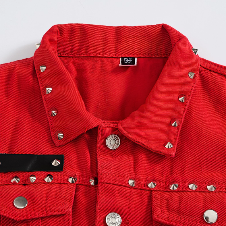 Close-up of red denim vest collar with silver cone studs and branded metal snap button details
